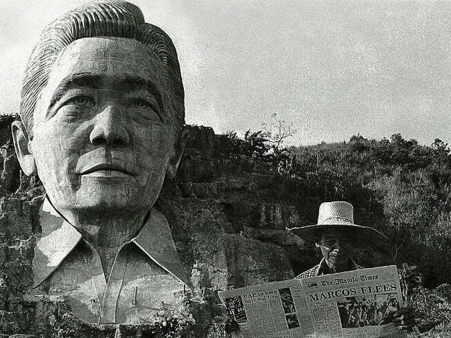 A farmer in Agoo, La Union, standing in front of the Marcos monument, reads about it the following day in a newspaper carrying the headlines “Marcos Flees.”