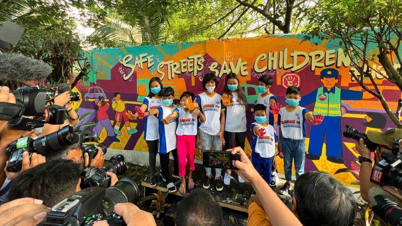 Children unveil a mural to urge government and stakeholders to commit to safer roads for vulnerable road users.