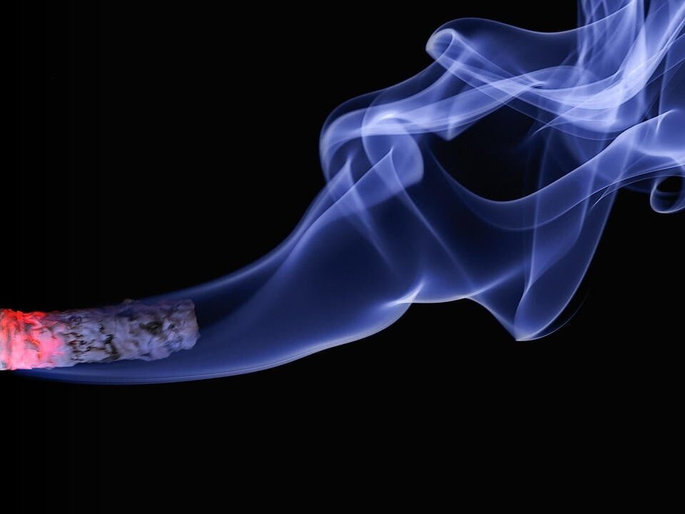 A burning cigarette with smoke